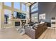 Inviting living room with a stone fireplace, large windows, and a comfortable leather seating area at 7378 Geode Ct, Castle Rock, CO 80108