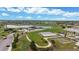An aerial view showcases the community park, including a playground, lake, sports courts, and walking paths at 10759 Clermont St, Thornton, CO 80233