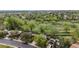 An aerial view shows the community's green spaces, mature trees, and walking trails near residential houses at 10759 Clermont St, Thornton, CO 80233
