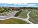 The aerial shows a park with a walking path leading to a building with a large parking lot at 10759 Clermont St, Thornton, CO 80233