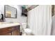 Bathroom with dark vanity, modern fixtures, ceramic tile, and shower with curtain at 10759 Clermont St, Thornton, CO 80233