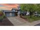 Charming two-story home featuring a well-maintained front yard and attached two-car garage with beautiful sunset at 10759 Clermont St, Thornton, CO 80233