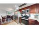 Eat-in kitchen featuring stainless steel appliances, granite countertops, and dark wood cabinetry with nearby dining area at 10759 Clermont St, Thornton, CO 80233
