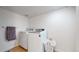 Laundry room with white washer and dryer, tile floor, and a laundry basket at 10759 Clermont St, Thornton, CO 80233