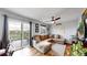 Bright living room featuring a comfy sectional, wood floors, sliding glass door to a balcony, and a ceiling fan at 10759 Clermont St, Thornton, CO 80233