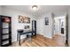 Functional home office with wood floors, desk, shelving, and neutral wall color at 10759 Clermont St, Thornton, CO 80233