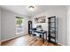 Functional home office with wood floors, desk, shelving, and a bright window with lots of natural light at 10759 Clermont St, Thornton, CO 80233
