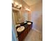 Bathroom with dual sinks, wooden cabinetry, and a large mirror at 15700 E Jamison Dr # 3-202, Englewood, CO 80112