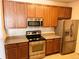 Kitchen featuring stainless steel appliances, granite countertops, and wood cabinets at 15700 E Jamison Dr # 3-202, Englewood, CO 80112