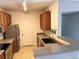 Kitchen featuring stainless steel appliances, granite countertops, wood cabinets, and tile flooring at 15700 E Jamison Dr # 3-202, Englewood, CO 80112