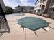Community pool featuring a safety cover, surrounded by black metal fencing and residential buildings on a sunny day at 15700 E Jamison Dr # 3-202, Englewood, CO 80112