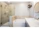 Bright bathroom features a shower over tub, stylish vanity, and decorative shelving at 8427 E 35Th Ave, Denver, CO 80238