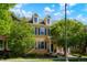 Attractive two-story townhome with dormer windows and blue shutters, nestled among mature trees at 8427 E 35Th Ave, Denver, CO 80238