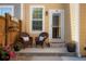 Inviting front porch with two wicker chairs and beautiful flower arrangements creating a warm welcome at 8427 E 35Th Ave, Denver, CO 80238