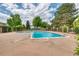 Community pool surrounded by lush landscaping and mature trees on a sunny day at 3351 S Field St # 191, Lakewood, CO 80227