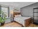 Bedroom featuring hardwood floors, gray accent wall, and shelf near the window at 13950 E Oxford Pl # A-104, Aurora, CO 80014