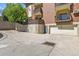 View of a concrete parking area and garage doors underneath balconies on a brick condominium building at 13950 E Oxford Pl # A-104, Aurora, CO 80014