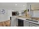 Bright kitchen with breakfast bar, stainless steel sink, white cabinets, and view into the living room at 13950 E Oxford Pl # A-104, Aurora, CO 80014