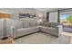 Comfortable living room with light gray sectional sofa, neutral rug, lots of natural light, and modern accents at 13950 E Oxford Pl # A-104, Aurora, CO 80014