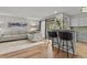 Open concept living room and kitchen with bar stool seating, light gray sectional sofa, and lots of natural light at 13950 E Oxford Pl # A-104, Aurora, CO 80014