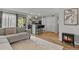 Spacious living room with gas fireplace, light gray sectional sofa, modern decor, and open access to kitchen at 13950 E Oxford Pl # A-104, Aurora, CO 80014