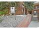 Exterior view of the condo main lobby entrance and signage surrounded by mature trees and lush landscaping at 13950 E Oxford Pl # A-104, Aurora, CO 80014