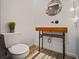 Unique powder room features a porthole mirror and custom wood vanity with industrial style plumbing at 1625 Larimer St # 3004, Denver, CO 80202