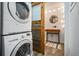 Functional laundry area with stacked washer and dryer, alongside a quaint half-bath with a rustic vanity at 1625 Larimer St # 3004, Denver, CO 80202