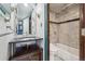 A charming bathroom featuring a vessel sink on a wooden vanity and marble tiling in the shower/tub combo at 8822 E Florida Ave # G07, Denver, CO 80247