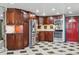 A kitchen featuring stainless steel appliances, dark wood cabinetry, and distinctive black and white tiled flooring at 8822 E Florida Ave # G07, Denver, CO 80247