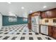 Spacious kitchen features stainless steel appliances, dark wood cabinetry, and black and white tiled floor at 8822 E Florida Ave # G07, Denver, CO 80247