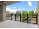 Balcony with black metal fencing, offering views of the street, lush trees, and clear blue skies at 7700 E 29Th Ave # 102, Denver, CO 80238