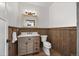 Rustic bathroom featuring wood paneling, a vanity sink, and a well-lit mirror at 7700 E 29Th Ave # 102, Denver, CO 80238