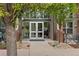 Close up of building entrance with double doors, brick accents and large windows at 7700 E 29Th Ave # 102, Denver, CO 80238