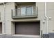 Exterior shot of a home showcasing its garage, second story balcony, and modern architectural style at 7700 E 29Th Ave # 102, Denver, CO 80238