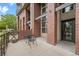 Brick condo building with metal accents and front patios with chairs and tables at 7700 E 29Th Ave # 102, Denver, CO 80238