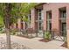 Brick condo building with metal accents and front patios surrounded by lush, manicured landscaping at 7700 E 29Th Ave # 102, Denver, CO 80238