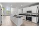 Bright, white eat-in kitchen features an island, stainless appliances, and lots of natural light at 7700 E 29Th Ave # 102, Denver, CO 80238
