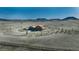 Scenic aerial view of a horse property with a residence, barns, and fenced pastures set against a mountain backdrop at 11524 Spruce Mountain Rd, Larkspur, CO 80118