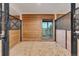 Horse stall showcasing wood paneling, hay bedding, and an outside view at 11524 Spruce Mountain Rd, Larkspur, CO 80118