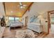 Bedroom with vaulted wood ceiling, wood floors, light blue accents and scenic view through large windows at 11524 Spruce Mountain Rd, Larkspur, CO 80118