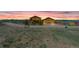 Front lawn and home on a horse property with driveway and a beautiful sunrise-colored sky at 11524 Spruce Mountain Rd, Larkspur, CO 80118
