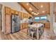 Spacious kitchen featuring stainless steel appliances, wooden cabinets, and a vaulted wood ceiling with decorative lighting at 11524 Spruce Mountain Rd, Larkspur, CO 80118