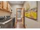 Modern laundry room with stainless steel washer and dryer, wooden cabinets, and stylish accents at 11524 Spruce Mountain Rd, Larkspur, CO 80118