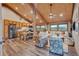 Open-concept living room and kitchen with wood floors, vaulted wood ceilings, and ample natural light from multiple windows at 11524 Spruce Mountain Rd, Larkspur, CO 80118