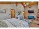 This main bedroom offers wooden ceilings, a ceiling fan, an artistic wall painting, and an ensuite bathroom at 11524 Spruce Mountain Rd, Larkspur, CO 80118