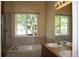 Bathroom featuring large soaking tub, double sinks, and large window at 213 Mesa St, Brighton, CO 80601