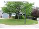 View of one-story home with a mature tree and a well-manicured front lawn at 213 Mesa St, Brighton, CO 80601