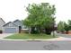 Charming one-story home featuring a well-manicured lawn and mature trees at 213 Mesa St, Brighton, CO 80601