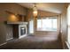 Cozy living room with a fireplace, large windows, and neutral color palette at 213 Mesa St, Brighton, CO 80601